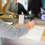 customer writing application at bank office