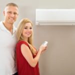 Couple With Remote Control Air Conditioner